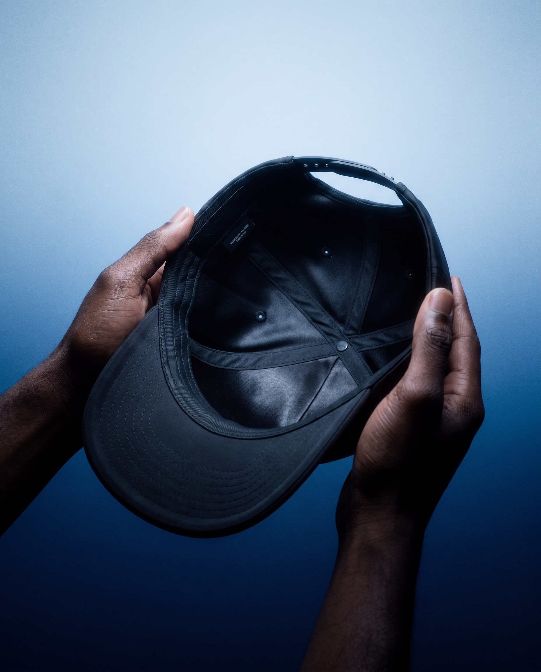 Hands holding a hat, showing the silk lining inside