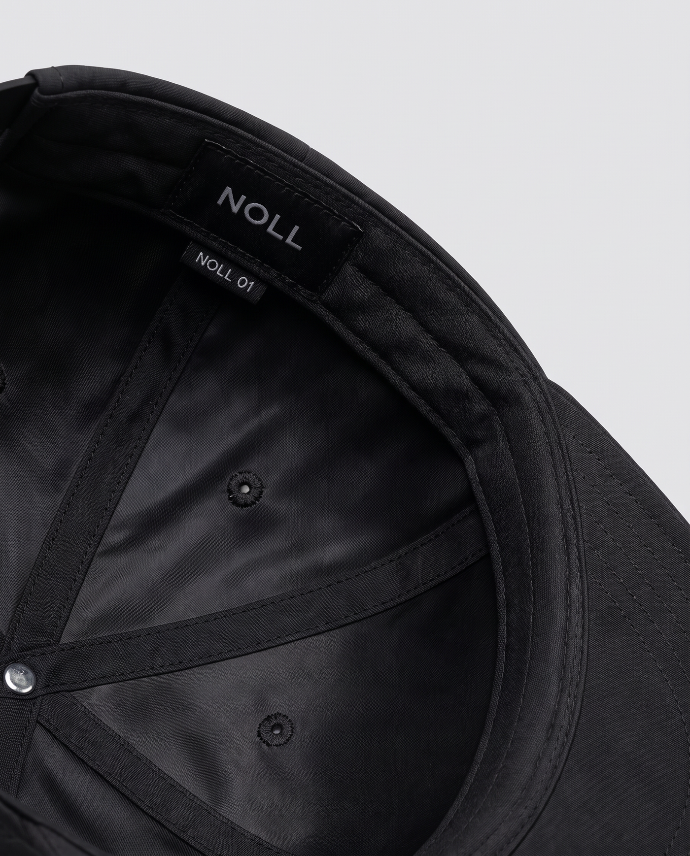 The silk-lined interior of the NOLL 01 cap, showing covered seams