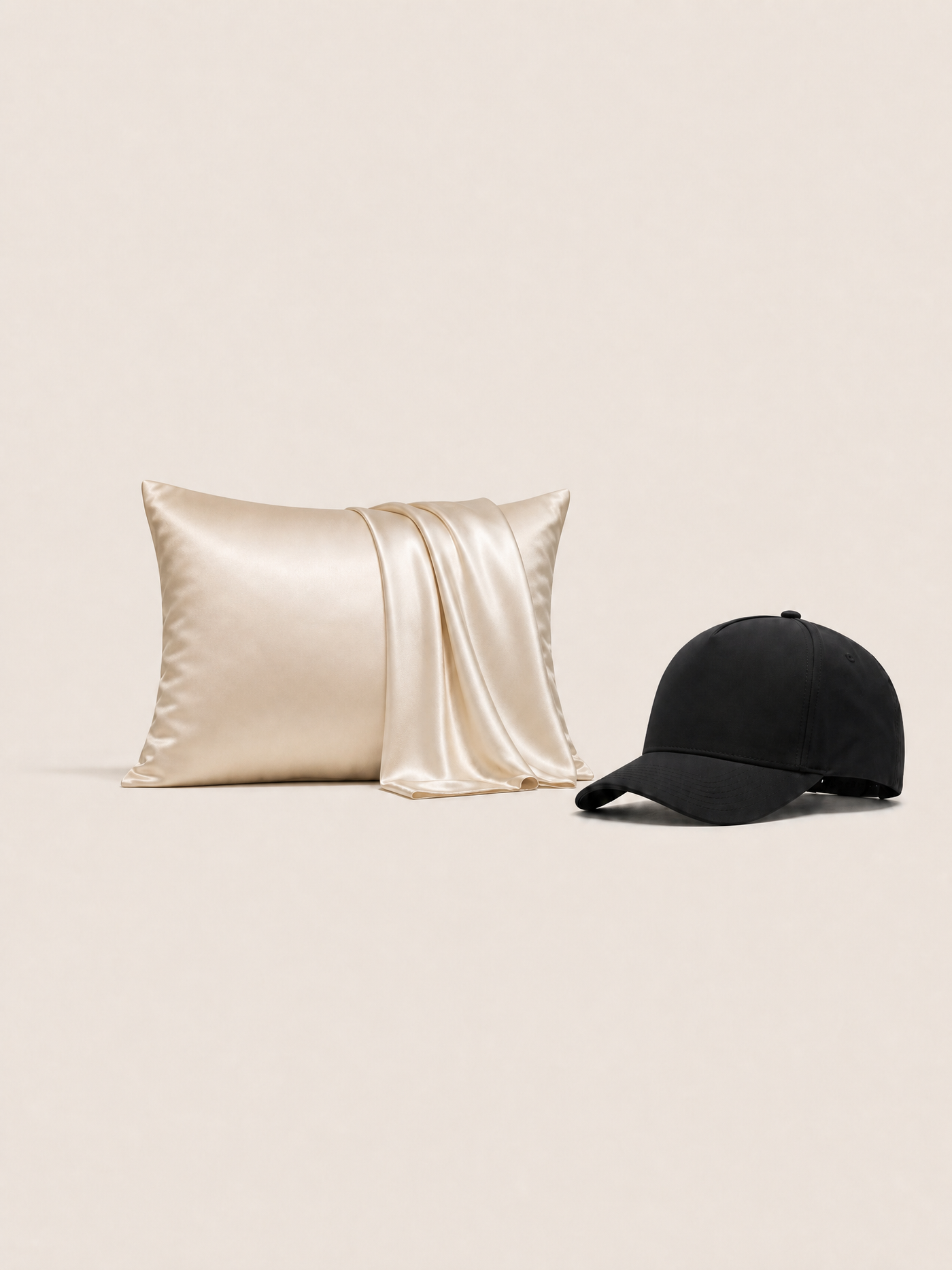 The ivory silk pillowcase beside the matte black NOLL 01 hat